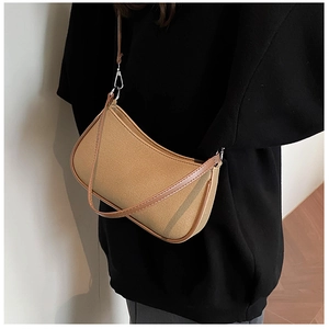 Detail of khaki canvas shoulder bag with brown leather trim and silver metal hardware