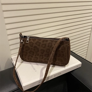 Close-up of leopard print shoulder bag with silver hardware on minimalist studio background