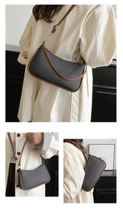 Detail showing soft leather underarm bag with brown trim and adjustable shoulder strap