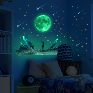 Luminous wall stickers featuring moon, stars, and deer silhouette glowing in the dark room