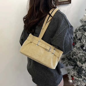 Chic beige suede underarm shoulder bag with silver metallic buckle on a model