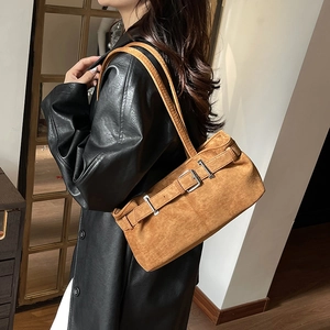 Retro brown suede underarm shoulder bag with buckle detail shown on a leather jacket model