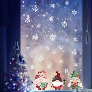 Detailansicht von weißen Schneeflocken-Aufklebern und bunten Weihnachtswichteln auf Glas