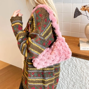 Sac fourre-tout rose en peluche avec texture fausse fourrure porté par un mannequin