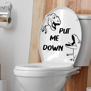 Close-up of dinosaur toilet seat sticker with Put Me Down slogan for bathroom decor