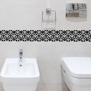 Detail of black and white floral waist line wall sticker on tiled bathroom wall