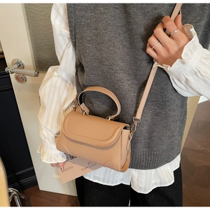 Detailed view of beige crossbody bag styled with a professional casual outfit