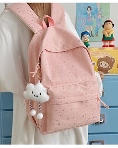 Zaino rosa con stelle argentate e ciondolo a nuvola in un ambiente scolastico