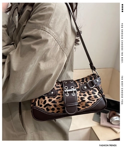 Detailansicht der Retro-Schultertasche mit Leopardenmuster und Schnallen auf Trenchcoat