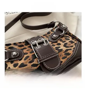 Macro detail of leopard print shoulder bag with silver buckles and contrast stitching