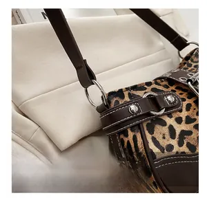 Close-up of leopard print fabric with brown leather trim and silver metal hardware details