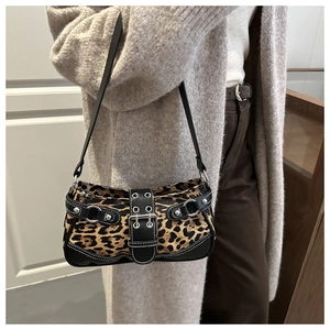 Close-up of leopard print shoulder bag with silver studs and buckles on model
