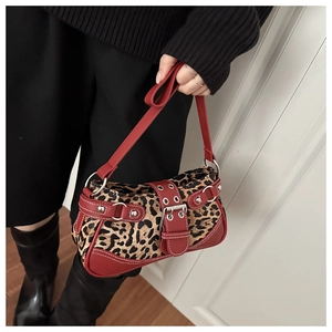 Detail of red leather strap and silver rivet studs on a leopard print shoulder bag