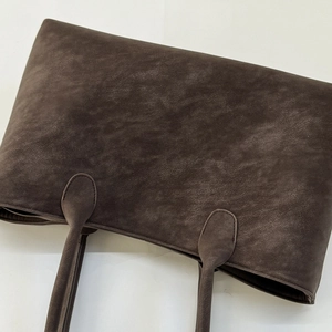 Close-up of vintage dark brown faux suede tote bag featuring premium leather texture