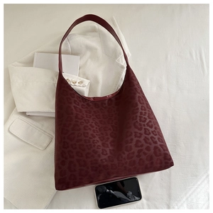 Macro view of burgundy leopard print tote bag with premium faux leather texture detail