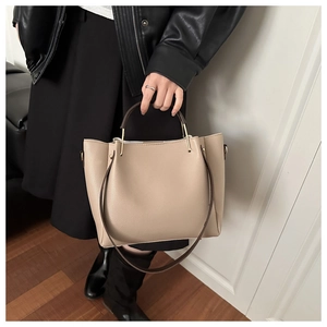 Détail du grand sac cabas beige grainé avec poignée dorée et bandoulière amovible