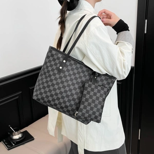Women black tote bag with geometric pattern and gold studs worn by model in white shirt
