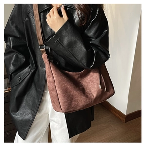 Brown suede crescent bag detail featuring matching wide textile strap and side drawstrings