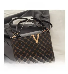 Close-up of vintage printed bucket bag with gold V-clasp and leather shoulder strap