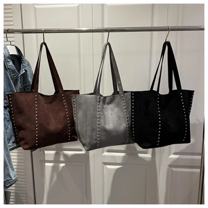 Close-up of vintage rivet tote bags in suede finish showing brown grey and black colors