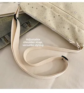 Détail de la bandoulière tissée réglable et broderie étoile argentée sur sac beige