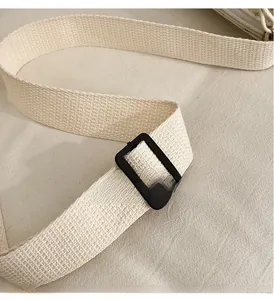 Détail de la bandoulière en toile tissée crème avec boucle de réglage noire
