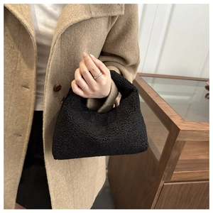 Detail of black faux shearling tote bag with textured lamb wool fabric for autumn
