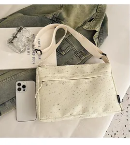 Détail du sac en toile à motif d'étoiles avec bandoulière réglable et zip argenté