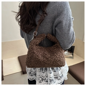 Détail d'un sac à bandoulière en peluche marron foncé avec texture en fausse fourrure