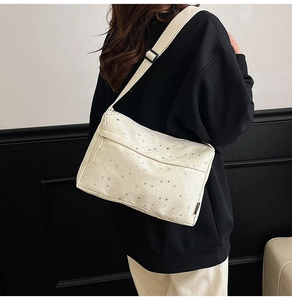 Détail du sac bandoulière en toile beige avec étoiles grises et sangle réglable