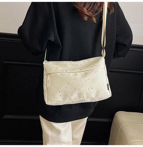 Détail du sac bandoulière blanc crème avec motifs étoiles argentées et sangle nylon