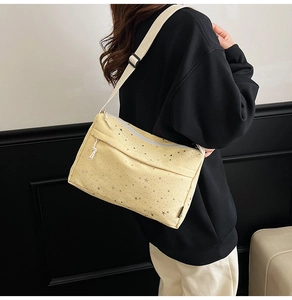 Vue latérale du sac bandoulière en toile jaune pâle avec imprimés étoiles et sangle