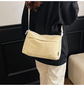 Détail du sac à bandoulière rectangulaire jaune avec étoiles argentées et zips blancs