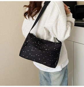 Détail du sac bandoulière noir avec motif étoiles blanches et bandoulière réglable