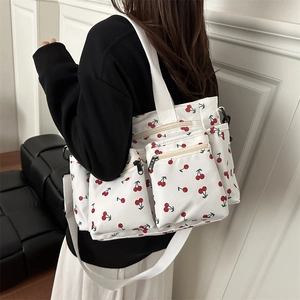 White cherry print tote bag with multi-pocket design and adjustable shoulder strap