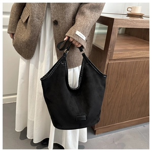 Détail d'un grand sac Hobo noir en daim avec coutures vintage en situation réelle