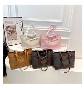 Détail de sacs cabas tissés en cinq couleurs avec sangles en simili cuir et boucles en métal