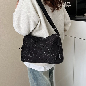 Sac bandoulière noir tendance avec motif étoiles blanches et sangle réglable sur mannequin