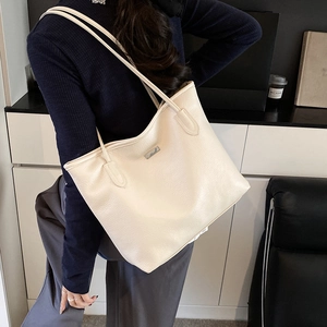 Minimalist beige pebble leather tote bag with metallic bar and long shoulder straps