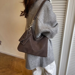 Brown textured leather tote bag with a small pouch and adjustable shoulder strap