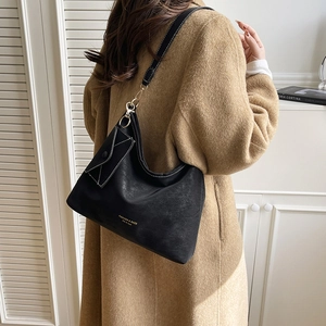 Black large capacity shoulder bag for women with envelope charm on model wearing camel coat