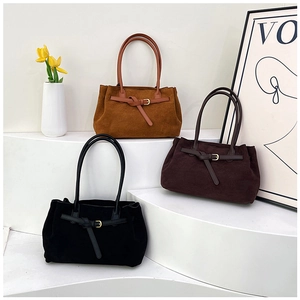 Three suede tote bags in black, coffee, and camel colors displayed on white stairs