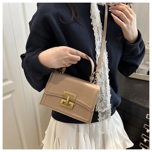 Chic beige square handbag detail showing smooth leather texture and gold metallic clasp