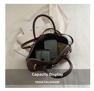 Deep brown suede handbag showing large capacity storage for smartphone and books