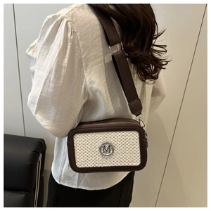 Détail d'un sac bandoulière rétro avec texture en tricot blanc et bordure en cuir marron