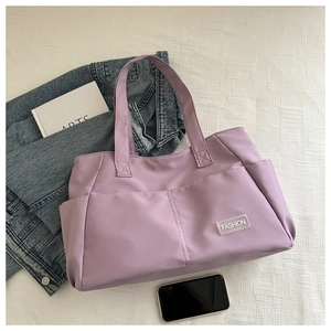 Close-up of lilac tote bag with multiple pockets and reinforced stitching detail