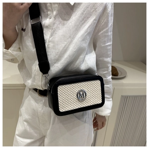 Détail du sac bandoulière carré avec cadre en cuir noir et panneau tissé crème