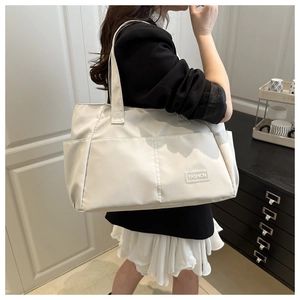 Detail of white nylon tote bag showing spacious capacity and fashion logo label