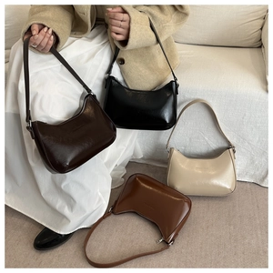 Detail view of half-moon underarm bags in black, coffee, caramel, and cream finishes