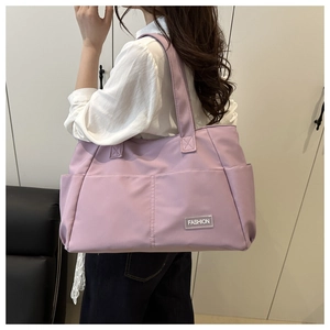Detailed side view of a purple large capacity tote bag with fashion tag on nylon material